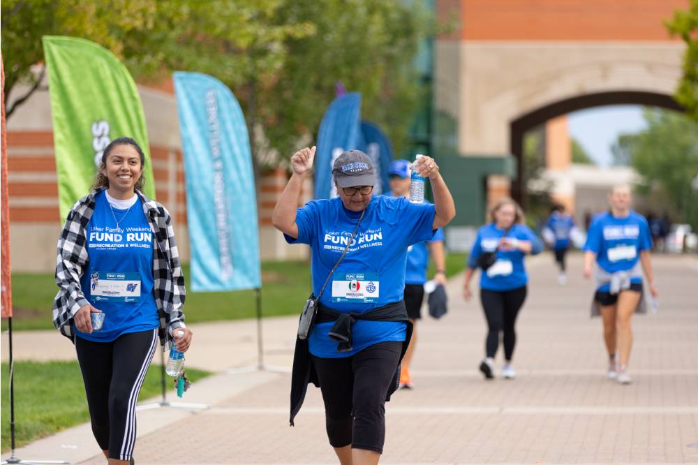 Participants nearing finish line celebrating by holding hands in the air